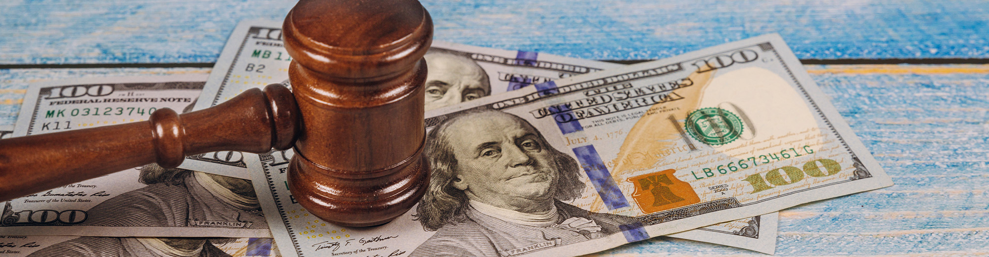 Judge gavel and money on blue wooden table