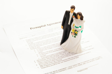 prenup papers with wedding cake topper people