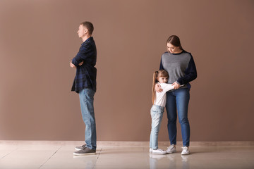 girl hugging her mom while her dad is sad