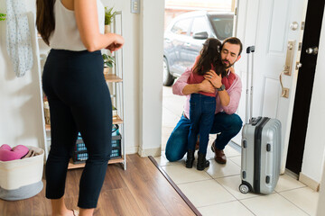 dad hugging daughter while mom watches at door