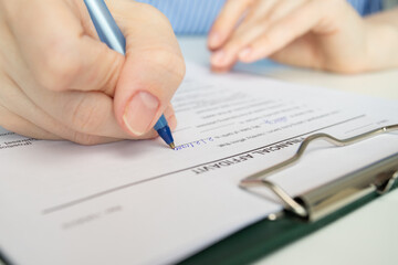 close up of person's hands writing on financial affidavit