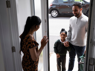 parents and child at door of house